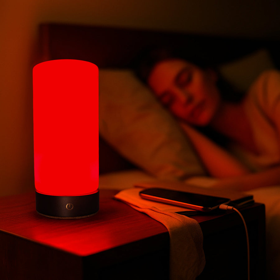 Woman asleep in bed with RŪBI glowing red on the nightstand