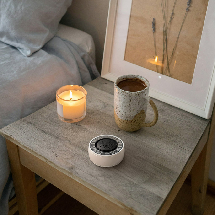 SIBŌ on a nightstand with a candle and a mug of tea